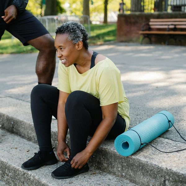 Person tying their shoelaces, preparing for a light exercise.